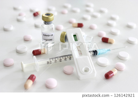 Positive test result of Covid-19 antigen test kit, Vial of Covid-19 vaccine, 1 ml plastic syringe with needle and drugs isolated on the white background Positive test result of Covid-19 antigen test kit, Vial of Covid-19 vaccine, 1 ml plastic syringe with needle and drugs isolated on the white background 126142921
