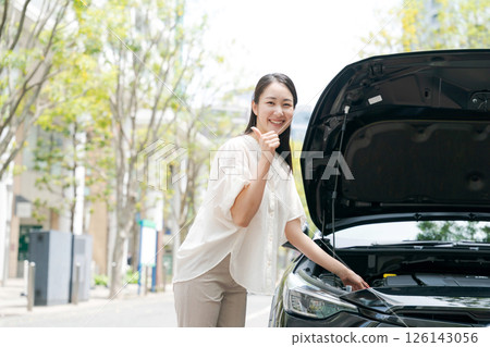 Woman opening the hood of a car Woman opening the hood of a car 126143056