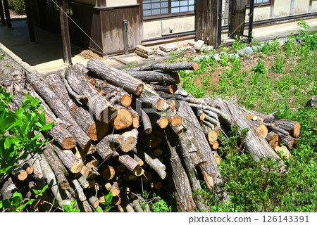 Logs stacked in front of a house 126143391