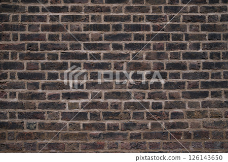 Close up of a weathered brick wall with visible texture and mortar lines in a traditional pattern. 126143650