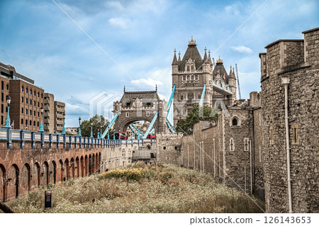 Tower Bridge rises behind the weathered stone walls of the Tower of London, linking past and present across the skyline. Tower Bridge rises behind the weathered stone walls of the Tower of London, linking past and present across the skyline. 126143653