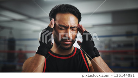 Man, headache and stress at gym for boxer by ring for fight, fatigue and concussion at training center. Person, migraine and athlete with pain, mixed martial arts and vertigo at fitness club Man, headache and stress at gym for boxer by ring for fight, fatigue and concussion at training center. Person, migraine and athlete with pain, mixed martial arts and vertigo at fitness club 126144081