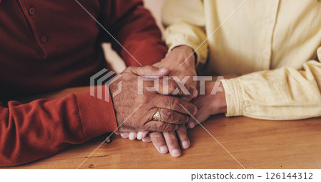 Home, table and old couple with holding hands for empathy, support and comfort to partner with grief. Closeup, senior people and love with sympathy for loss, compassion and kindness with commitment Home, table and old couple with holding hands for empathy, support and comfort to partner with grief. Closeup, senior people and love with sympathy for loss, compassion and kindness with commitment 126144312