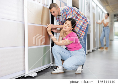 Couple of man and woman choose tiles in store Couple of man and woman choose tiles in store 126144340