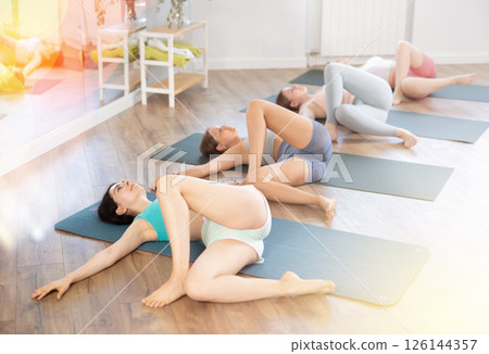 Female yoga studio and perform chatush padasana. Philosophy of active lifestyle in gym 126144357