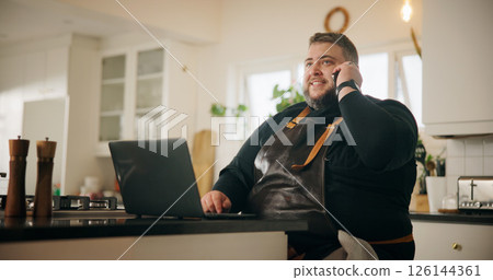 Phone call, chef and man with smile, kitchen and communication with supplier for ingredients order. Talking, cook and person with mobile for chat with contact, house and planning for menu with laptop 126144361