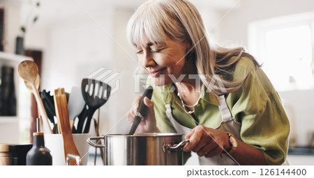Aroma, cooking and mature woman in kitchen in home with smelling dinner, meal or dish. Happy, pot and female person with satisfaction for scent of supper with health, wellness and nutrition in house. 126144400