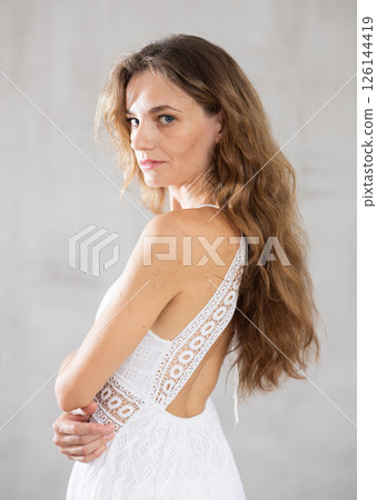 Young serious woman posing against wall background 126144419