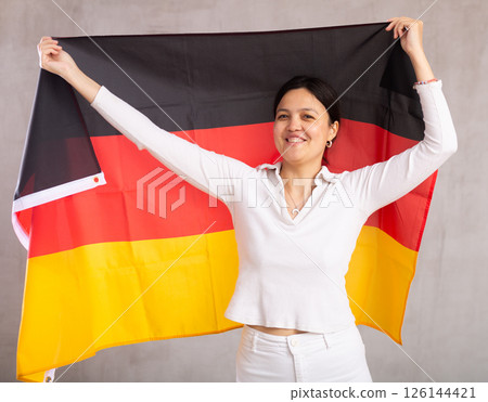 Young woman posing in studio with Germany flag Young woman posing in studio with Germany flag 126144421
