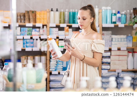 Woman in a beautiful dress scans a package of cream 126144474