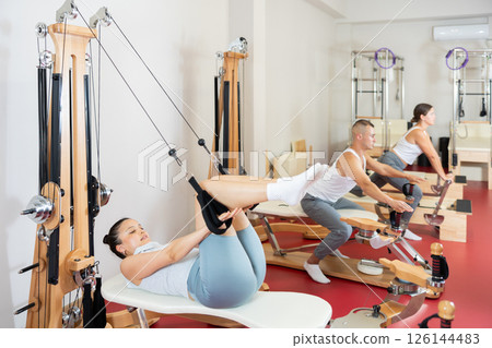 Young woman training her arms using straps 126144483