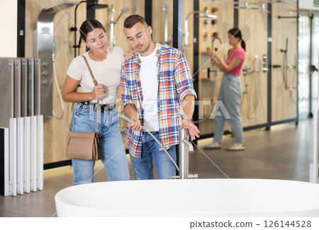 Couple man and woman choosing bath in store Couple man and woman choosing bath in store 126144528