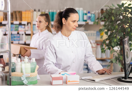 Female pharmacist working at computer in pharmacy Female pharmacist working at computer in pharmacy 126144549