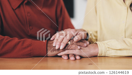 Home, table and old couple with holding hands for support, empathy and comfort to partner with grief. Closeup, senior people and love with sympathy for loss, compassion and kindness with commitment 126144619