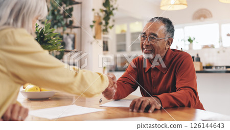 Home, documents and old man with financial advisor for handshake, greeting and deal for insurance. House, senior person and retirement planner with shaking hands for pension finance, saving and paper 126144643