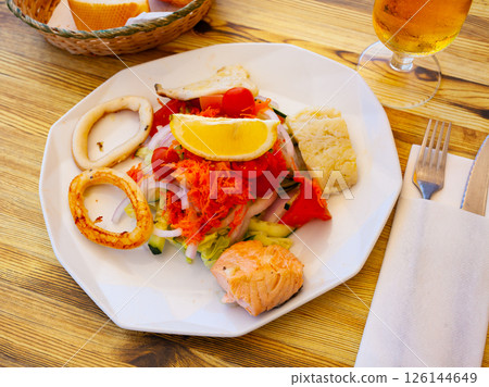 Seafood salad with grilled squid, salmon and vegetables 126144649