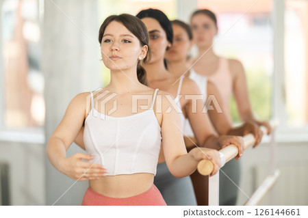 Young ballerinas practicing demi plie at barre in choreography studio 126144661