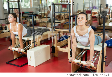 Active young girl doing press exercises on combo chair Active young girl doing press exercises on combo chair 126144671