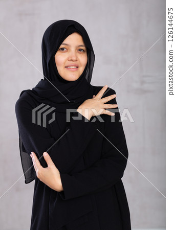 Positive young muslim woman wearing a hijab looking at camera studio Positive young muslim woman wearing a hijab looking at camera studio 126144675