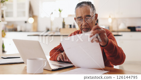 Senior man, documents and taxes with stress in home, reading and financial review for pension. Elderly person, laptop and thinking with budget, bills and confused with retirement income in kitchen 126144795