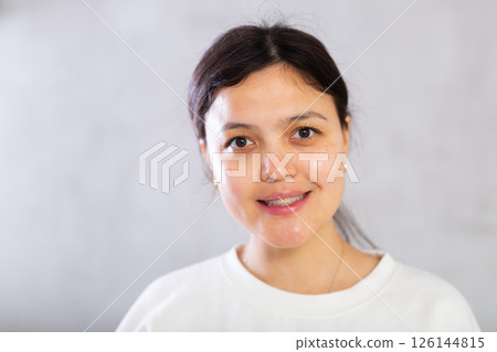 Closeup portrait of smiling young woman on gray background Closeup portrait of smiling young woman on gray background 126144815