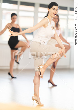 Slim brunette in heels practicing jazz-funk dance in studio Slim brunette in heels practicing jazz-funk dance in studio 126144838