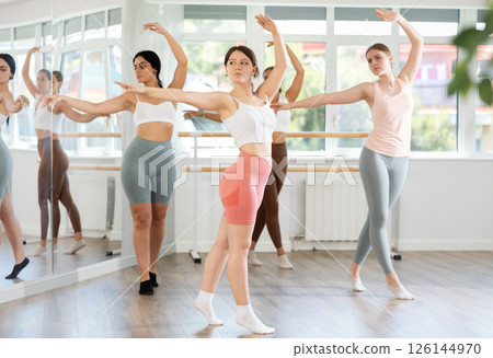Teenage girl participating in beginner group ballet class Teenage girl participating in beginner group ballet class 126144970
