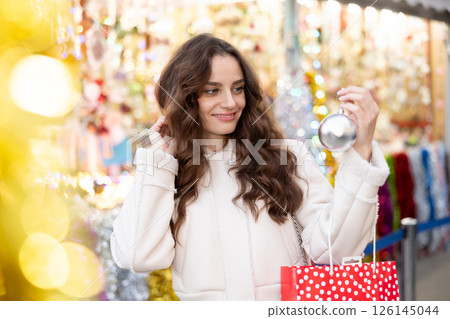 Woman choosing Christmas balls 126145044