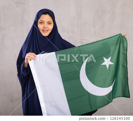 Young woman in hijab posing with Pakistan flag 126145100