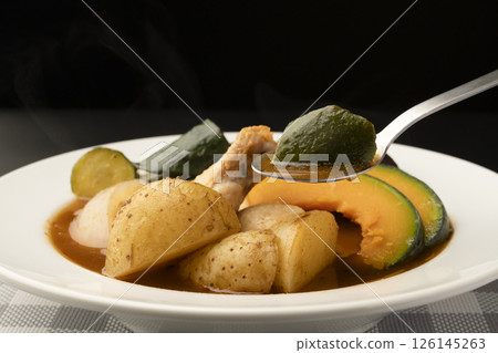 Picking up summer vegetable soup curry with a spoon Picking up summer vegetable soup curry with a spoon 126145263