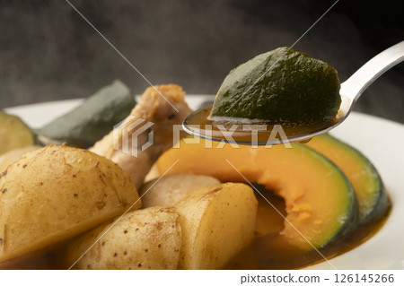 Picking up summer vegetable soup curry with a spoon Picking up summer vegetable soup curry with a spoon 126145266
