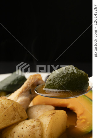 用湯匙舀起夏季蔬菜湯咖哩 用湯匙舀起夏季蔬菜湯咖哩 126145267
