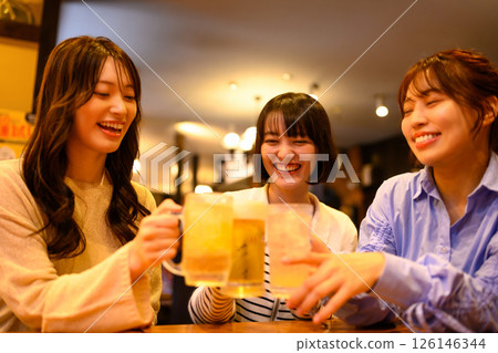 A woman in her twenties toasting at an izakaya A woman in her twenties toasting at an izakaya 126146344