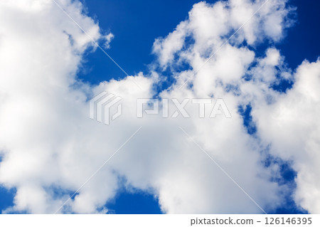 A beautiful blue sky filled with fluffy white clouds in it 126146395
