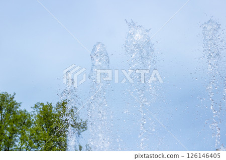 A beautiful fountain that sprays water, with trees in the background A beautiful fountain that sprays water, with trees in the background 126146405