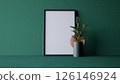 A minimalist interior scene featuring a blank frame green wall and a green plant on a textured green background. 3d rendering. 126146924