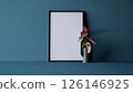 A minimalist interior scene featuring a blank frame and a stylish vase with a plant, blue wall. 3d rendering. 126146925