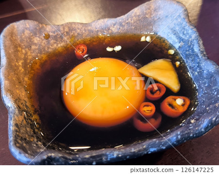 Raw Egg Yolk with Soy Sauce and Chili. japanese food 126147225