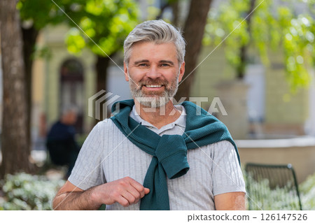 Portrait of happy bearded mature man smiling friendly, glad expression looking at camera relaxation Portrait of happy bearded mature man smiling friendly, glad expression looking at camera relaxation 126147526