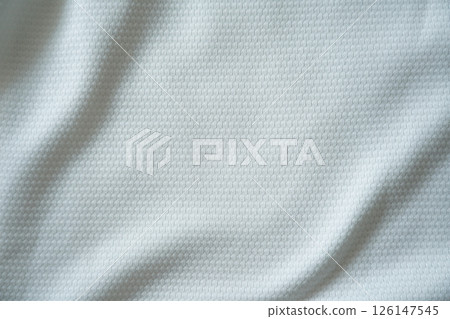 Close up of white football jersey sports clothing fabric texture. Close up of white football jersey sports clothing fabric texture. 126147545