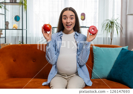 Choosing right nutrition pregnant woman comparing choosing between sweet donut and ripe apple Choosing right nutrition pregnant woman comparing choosing between sweet donut and ripe apple 126147693