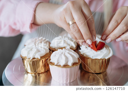 Decorating Cupcakes with Strawberries and Whipped Cream 126147710