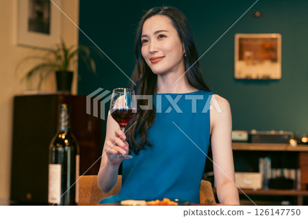 微笑的年輕女士拿著一杯葡萄酒 126147750