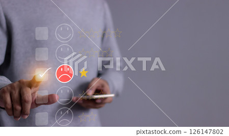 Young man hand holding smartphone to review and gives 1 star Young man hand holding smartphone to review and gives 1 star 126147802