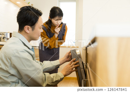 Male worker repairing a dishwasher Male worker repairing a dishwasher 126147841