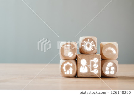Wooden blocks with icons symbolizing performance review, teamwork, and business strategy on a wooden surface. Wooden blocks with icons symbolizing performance review, teamwork, and business strategy on a wooden surface. 126148290