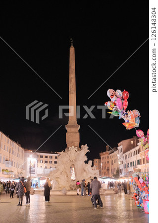 Night scene at Piazza Navona Rome with colorful balloons illuminated street lights and people in festive lively evening atmosphere Italy. High quality photo 126148304