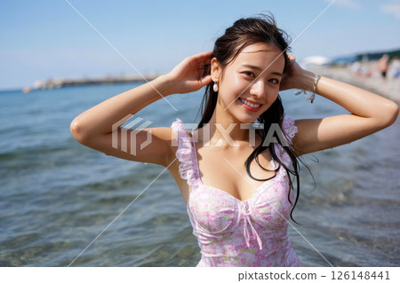A Japanese woman in a pink dress smiling at the sea in the countryside A Japanese woman in a pink dress smiling at the sea in the countryside 126148441