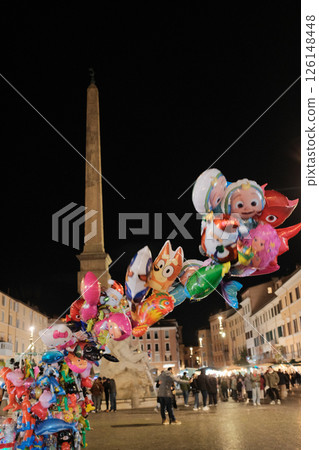Night scene at Piazza Navona Rome with colorful balloons illuminated street lights and people in festive lively evening atmosphere Italy. High quality photo 126148448