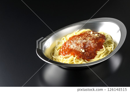 Meat sauce pasta topped with grated cheese photographed against a black background Meat sauce pasta topped with grated cheese photographed against a black background 126148515